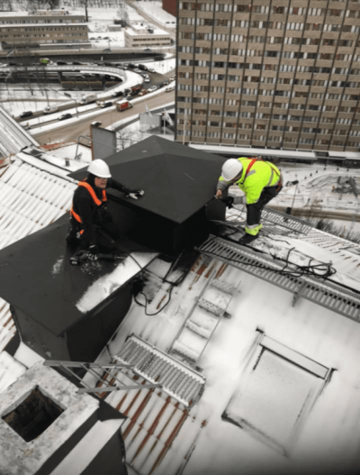 Tekniker installerar takfläkt på tak